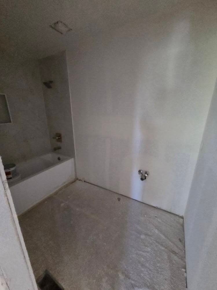 Small bathroom with white drywall walls and bathtub